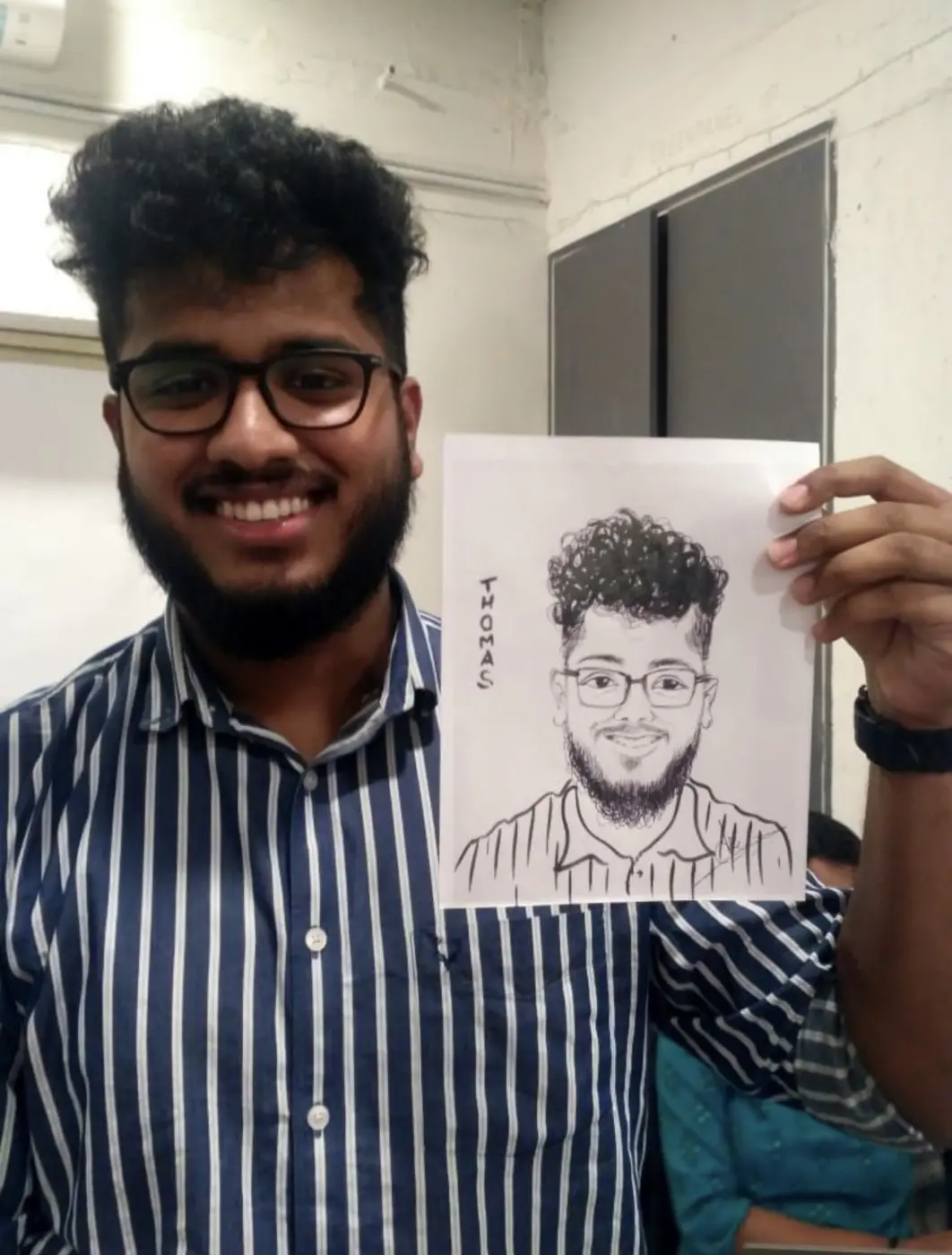 Live caricature artist holding a guest portrait at an event